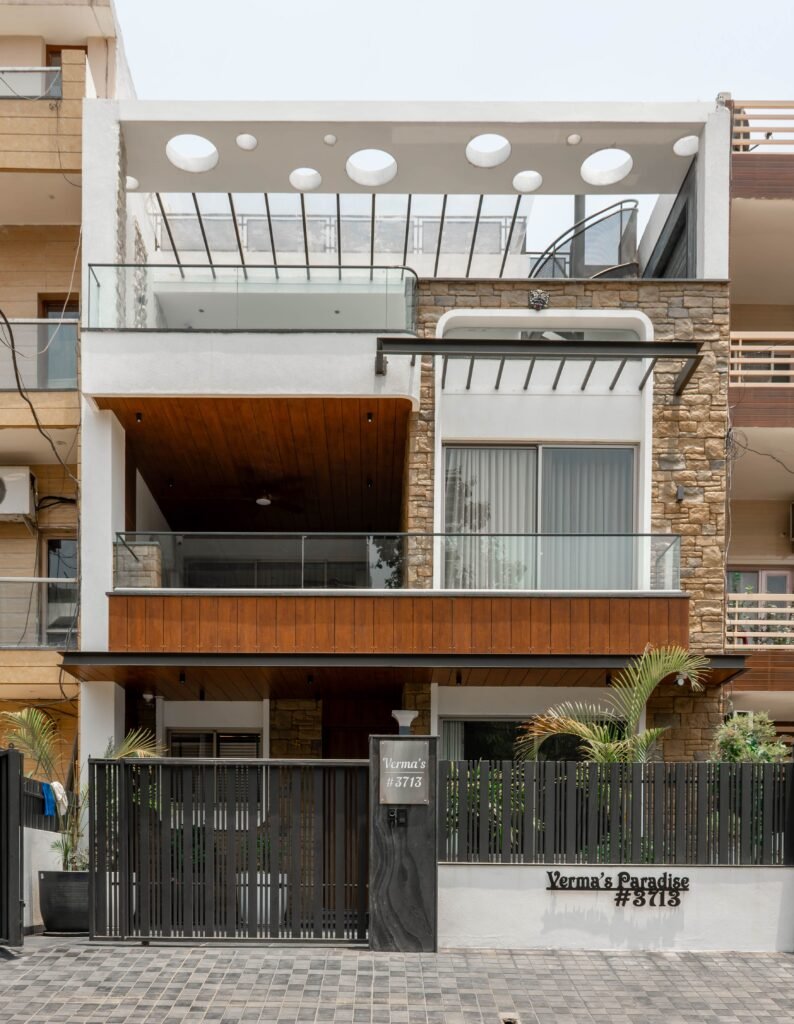 Contemporary urban home facade with circular cutouts and stone siding, offering a unique architectural style.